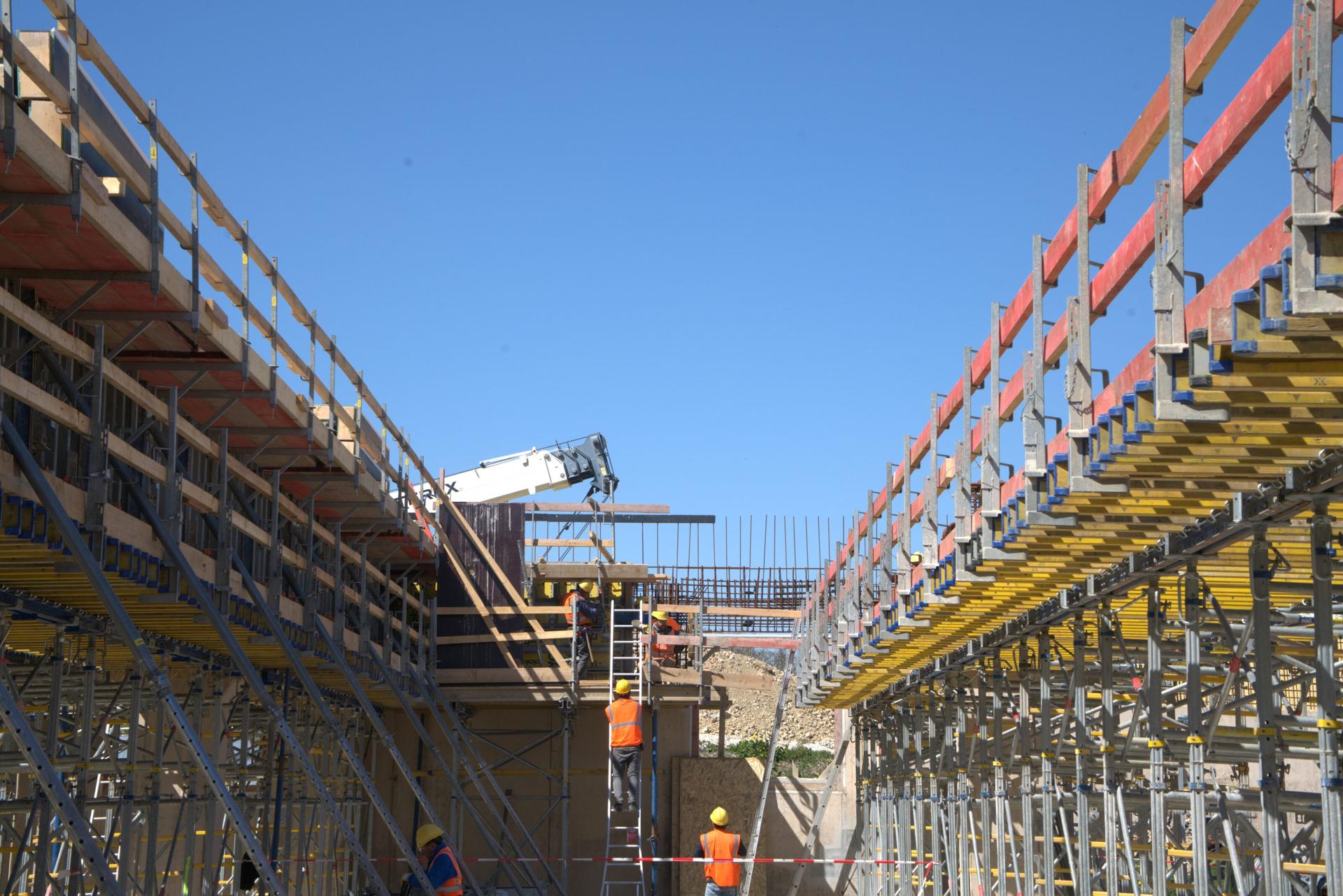 Workers on scaffolding at a 77 Construction site